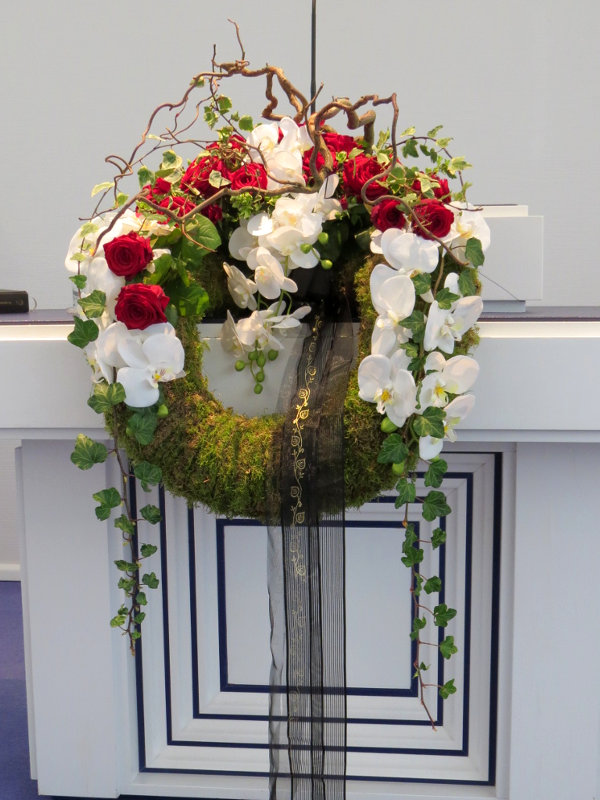 Altargesteck mit Rosen und Phalaenopsis auf einem Mooskranz